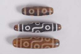 Three Tibetan agate dzi beads, largest 6cm