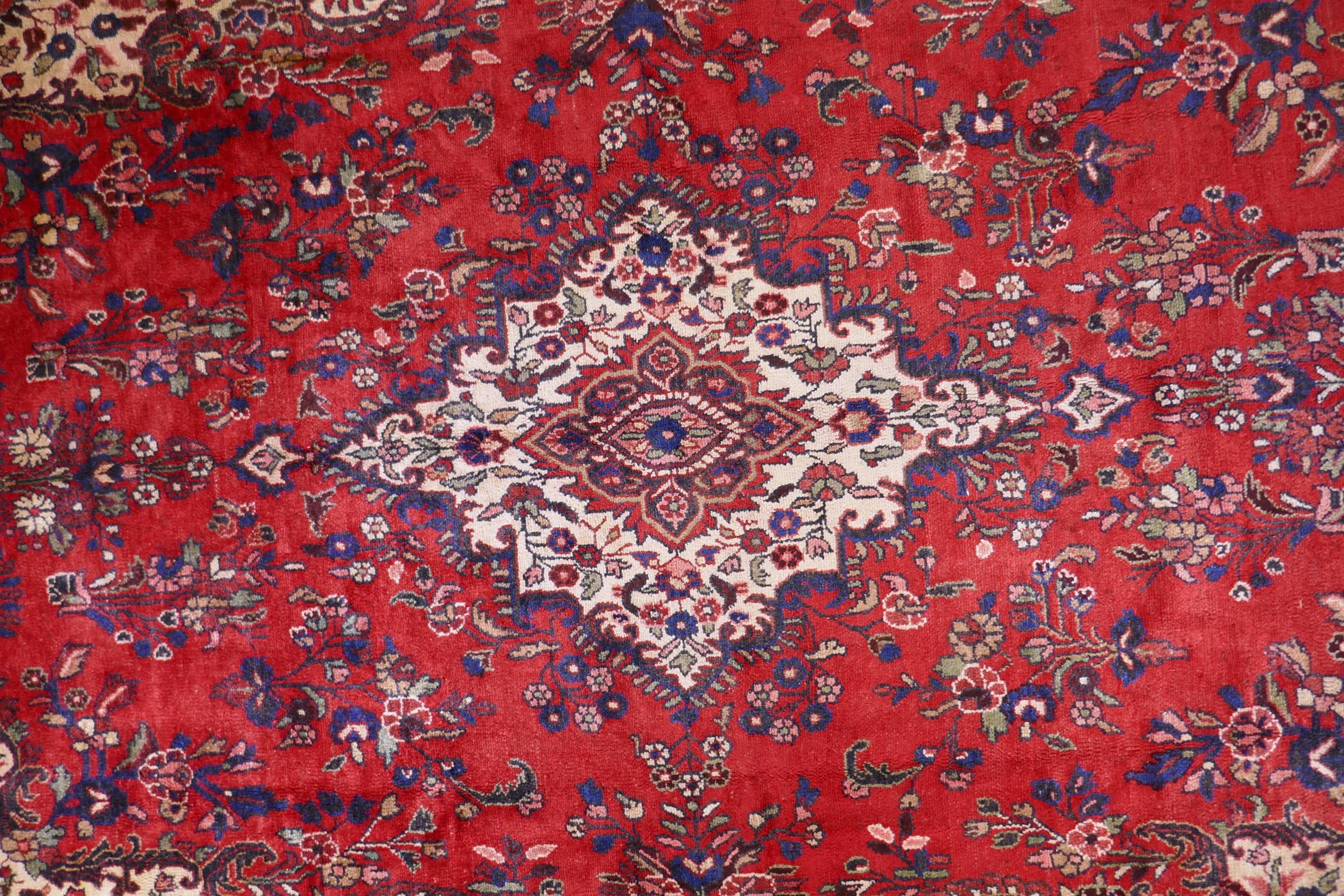 A Persian full pile red ground hand woven Sarouk village carpet with a floral medallion pattern - Image 4 of 6