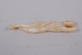 A carved bone ornament in the form of a female nude, 13cm long