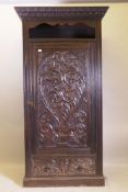 A C19th oak hall cupboard with single door over a drawer and carved decoration in the Renaissance