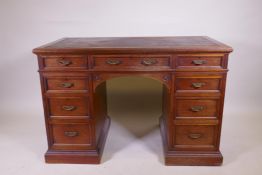 A fine quality solid walnut kneehole desk with inset gilt tooled leather top stamped Howard &