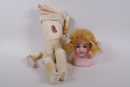 An antique German Bisque dolls head with open and shut eyes, and an associated torso, the head