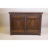 An oak blanket chest, with lift up top, carved frieze and panelled front and sides, raised on