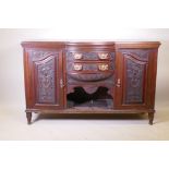 A Victorian walnut sideboard with carved decoration, two cupboards flanking two bow fronted drawers,