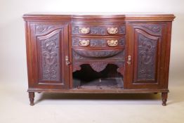 A Victorian walnut sideboard with carved decoration, two cupboards flanking two bow fronted drawers,