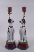 A pair of polychrome porcelain and gilt metal candlesticks in the form of dogs, 34cm high