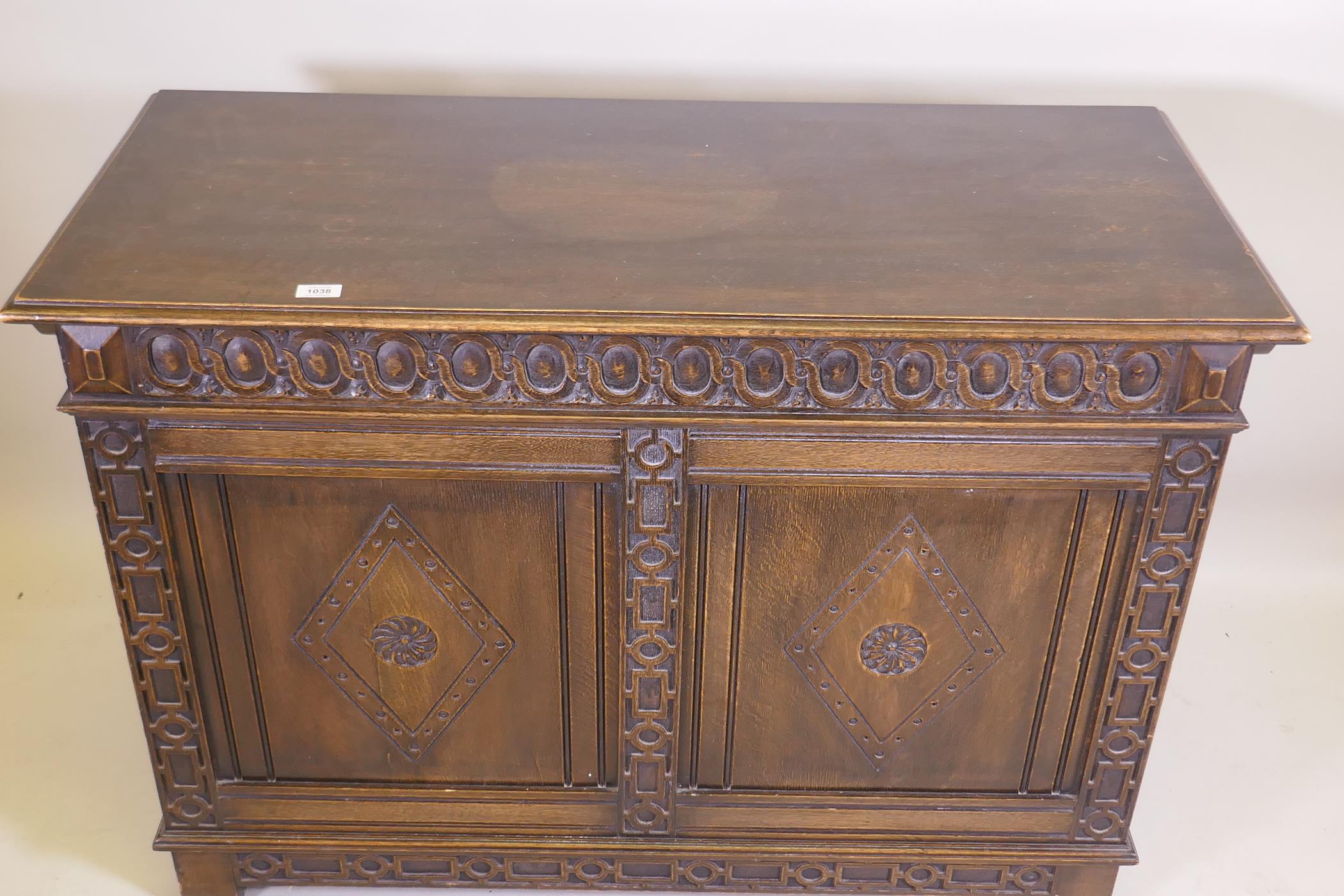 An oak blanket chest, with lift up top, carved frieze and panelled front and sides, raised on - Image 2 of 4