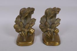 A pair of brass bookends with pine cone decoration, marked PMC 86, 14cm high