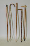 Three horn handled walking sticks including one with a silver mount, and two other wood walking