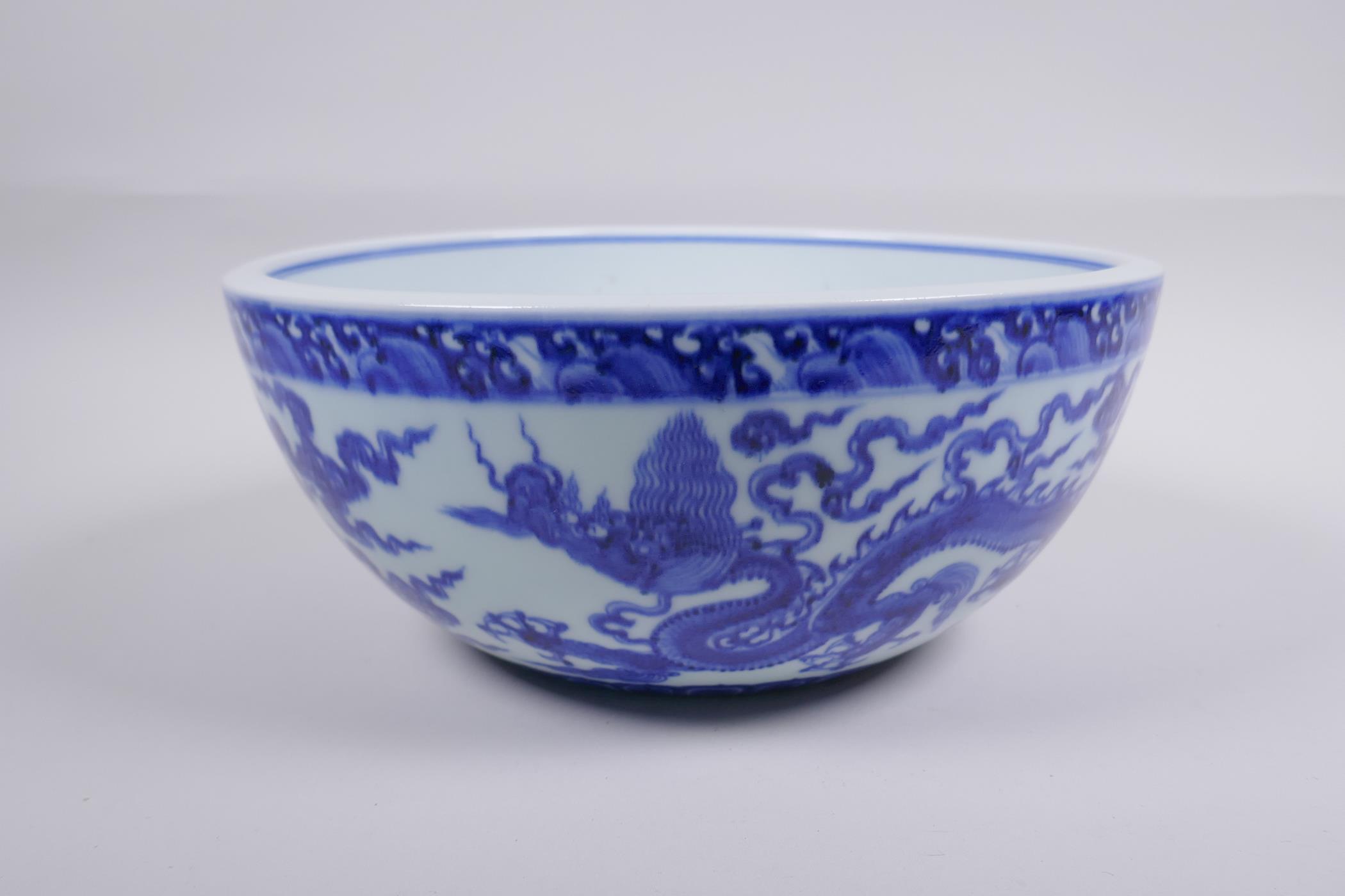 A blue and white porcelain bowl decorated with dragons in flight, Chinese Xuande 6 character mark to