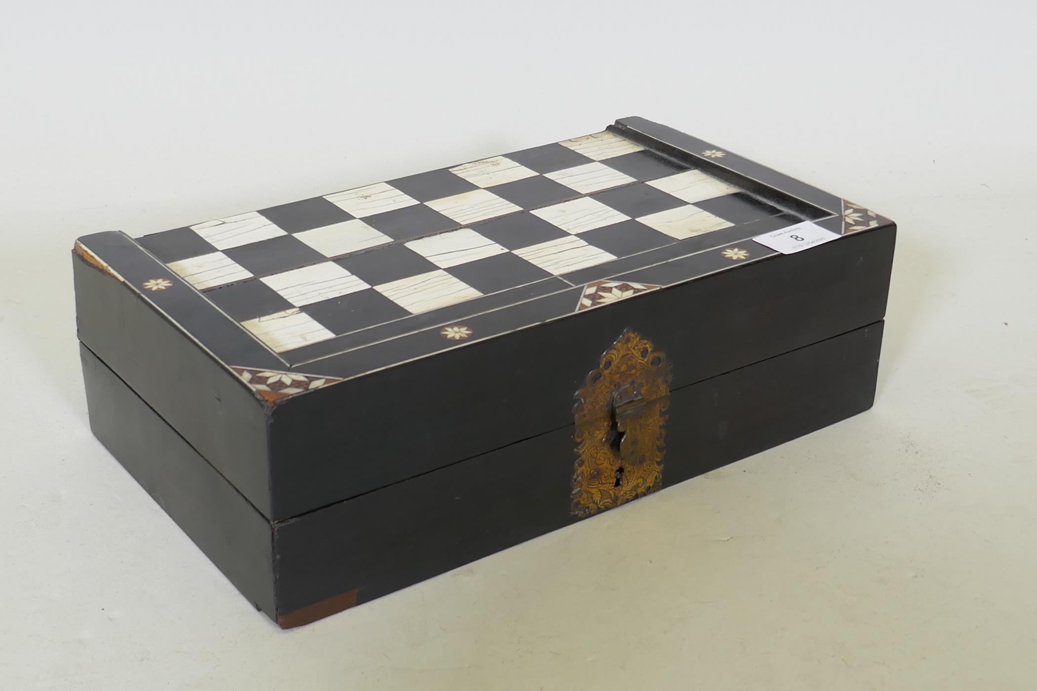 A C19th ebony and ivory and stained bone games box, with chequer board top and backgammon