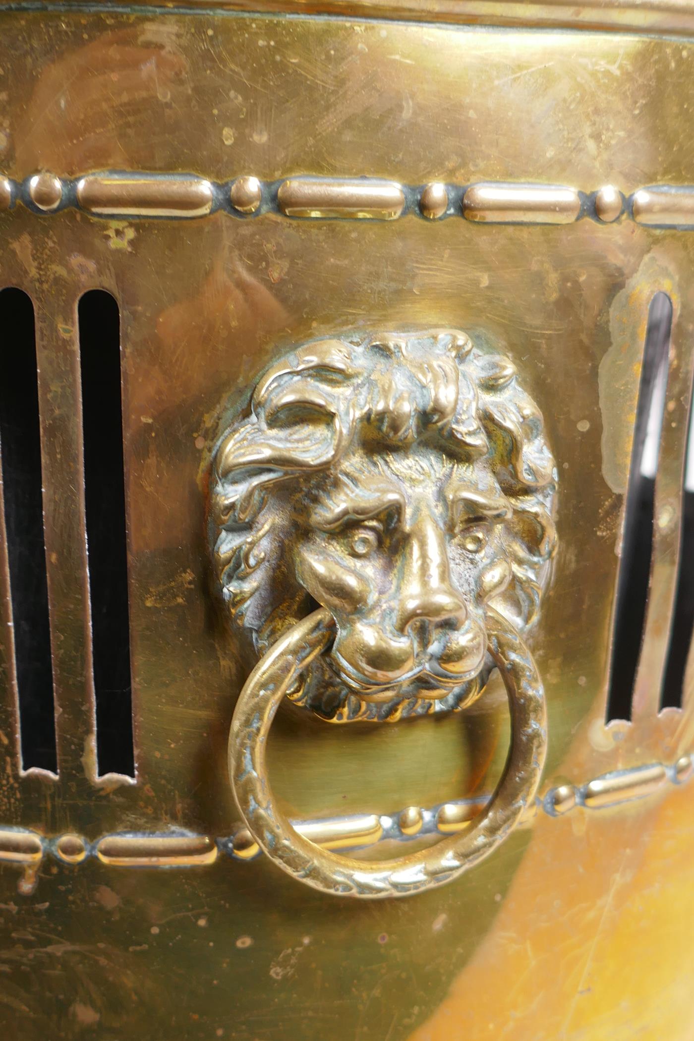 An antique brass coal scuttle with two lion mask loop handles, rams mask decoration and pawed - Image 3 of 4