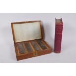 A boxed set of vintage opticians lenses, together with Diseases of the Eye by Sir John Herbert