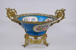 An ormolu mounted Sevres style porcelain centrepiece with decorative panels depicting a courting