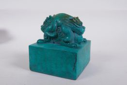 A Chinese reconstituted turquoise blue hardstone seal with a twin headed mythical creature knop,