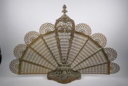 An antique pierced brass peacock fan fire screen, AF, 60cm high