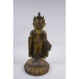 A Sino Tibetan gilt bronze figure of Buddha standing on a lotus flower, 32cm high