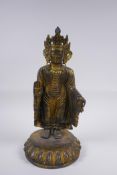 A Sino Tibetan gilt bronze figure of Buddha standing on a lotus flower, 32cm high