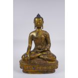 A Sino Tibetan filled gilt bronze figure of Buddha, impressed double vajra mark to base, 30cm high