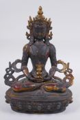 A Sino Tibetan bronze figure of Buddha, with remnants of gilt and copper patina, 22cm high