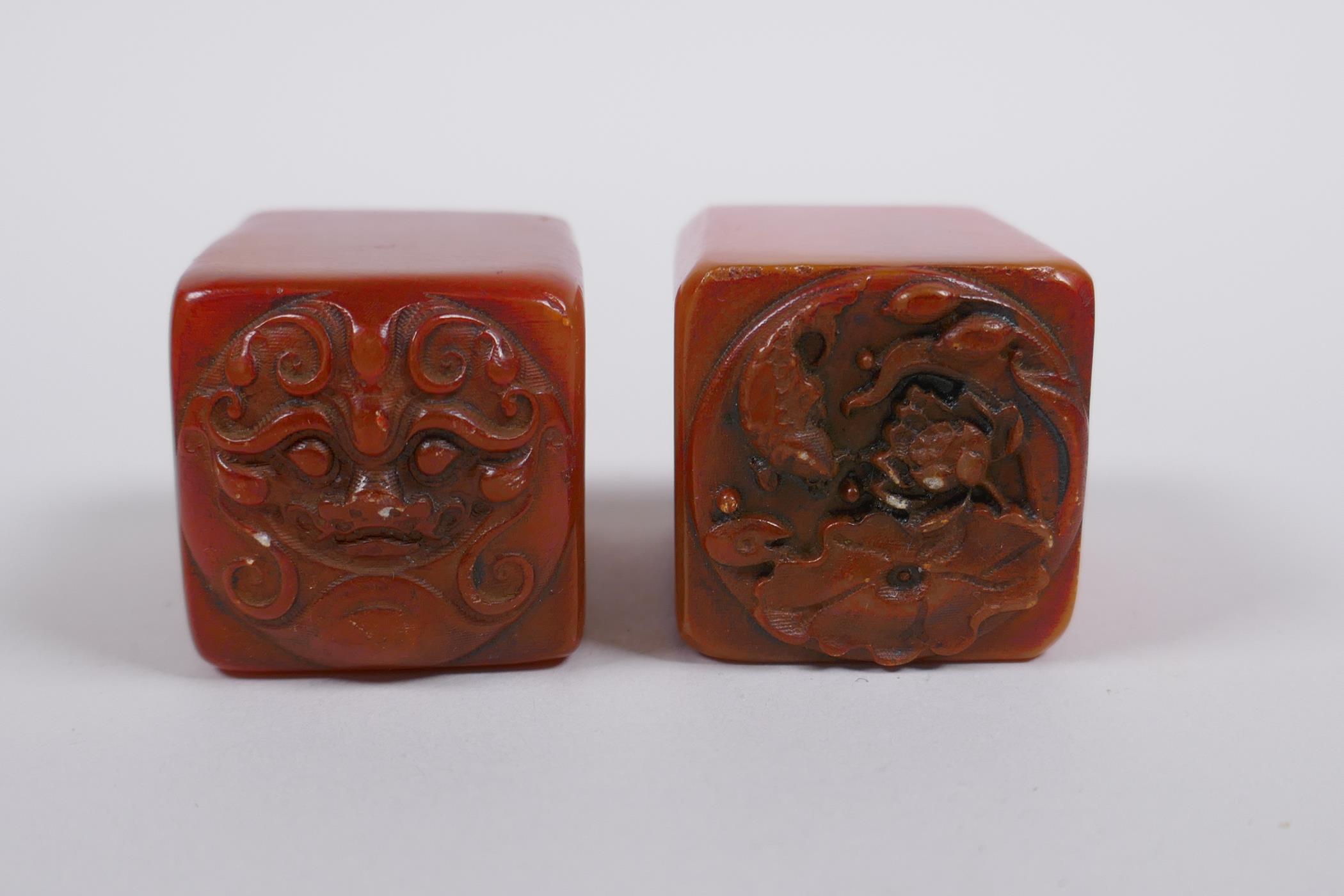 A pair of Chinese amber soapstone seals with dragon mask and lotus pad decoration, 3 x 3cm, 4cm high - Image 2 of 3