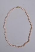 An 'Angel Skin' coral bead necklace with 14ct gold clasp, 46cm long