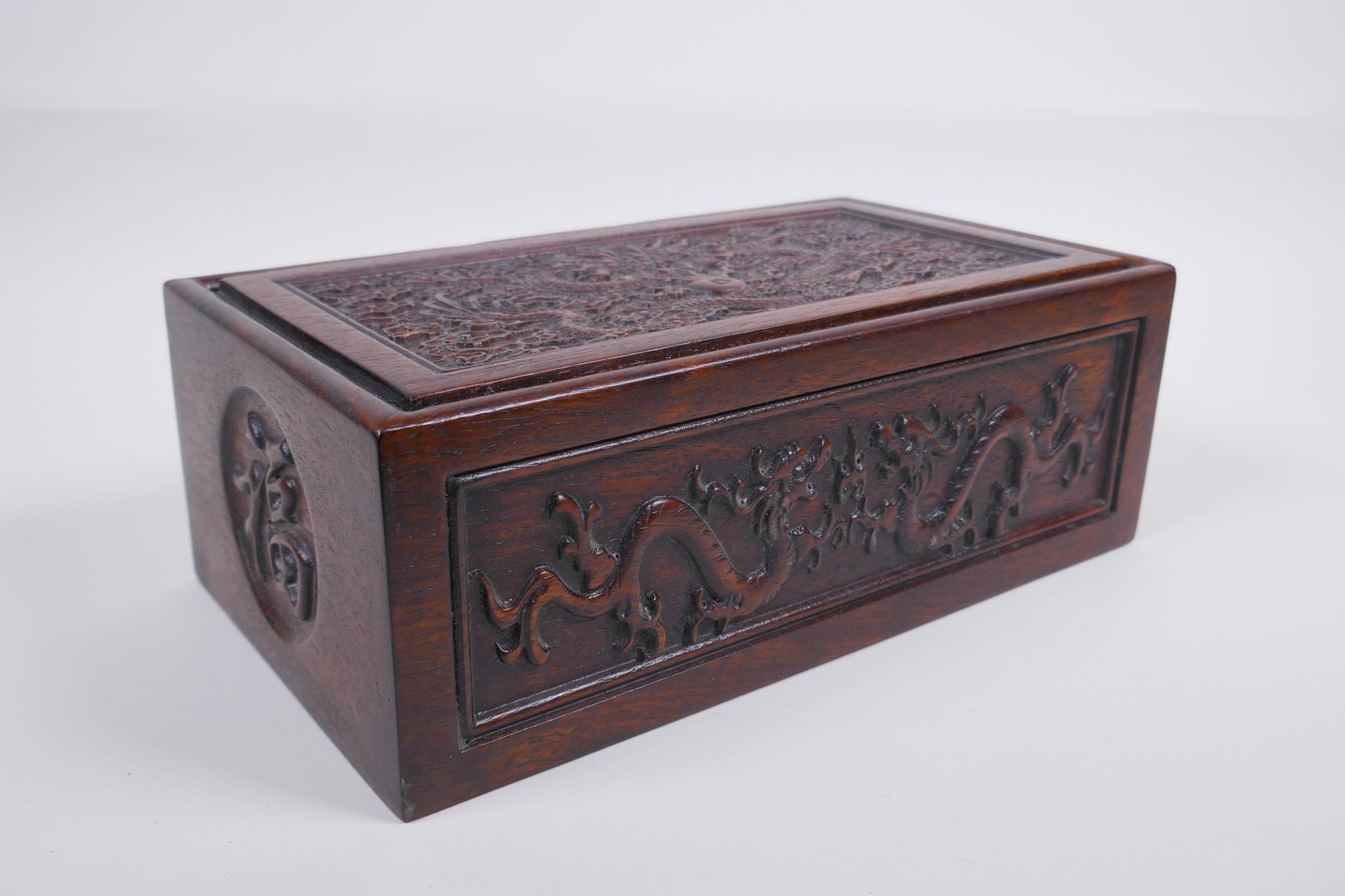 A Chinese carved hardwood box with dragon and character decoration, 28 x 16cm