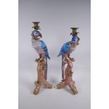 A pair of polychrome porcelain and gilt metal mounted parrot candlesticks, 52cm high