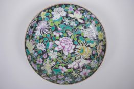 A Chinese famille noir porcelain dish decorated with asiatic flowers, YongZheng 6 character mark