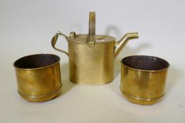 A brass watering can, 30cm high, and a pair of antique brass planters with engraved floral designs
