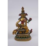 A Tibetan painted and gilt bronze figure of a deity seated on a mythical creature, 20cm high