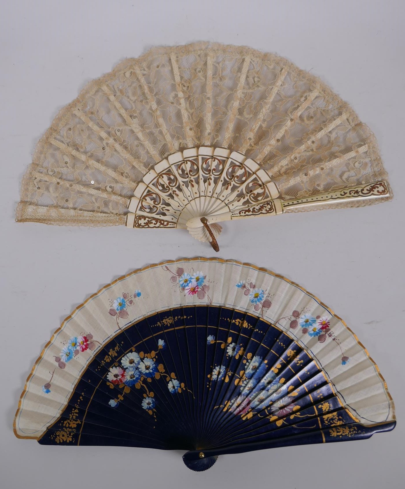 An antique carved wood and lace fan with gilt detail, together with linen and wood fan with hand