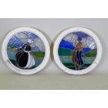 A pair of pine framed round window with stained glass depicting a Dutch boy and girl, 60cm diameter