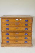 An early C20th golden oak plan chest in two sections of three drawers, 95 x 69cm, 89cm high