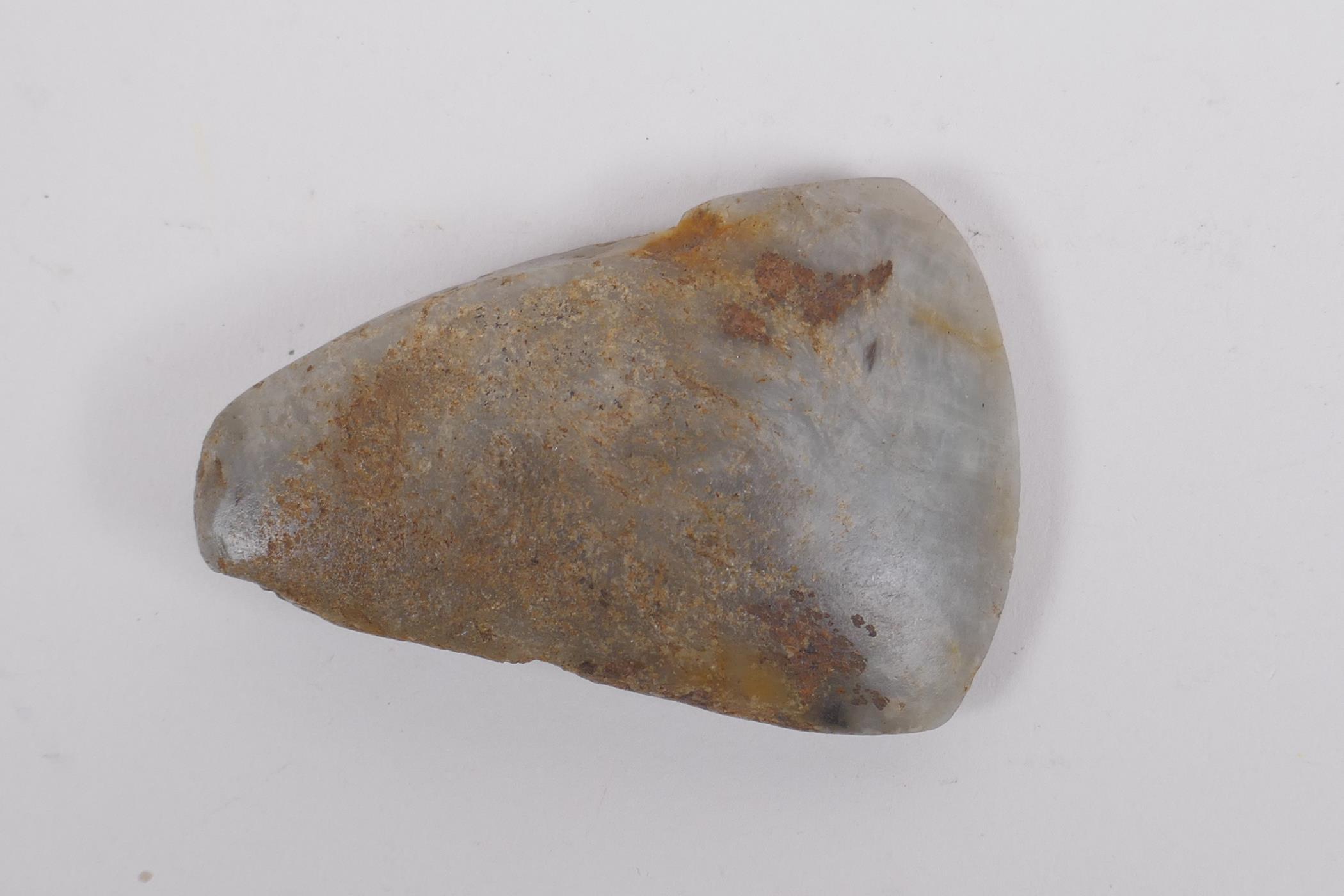 A Neolithic polished hardstone axe head, 8 x 5cm