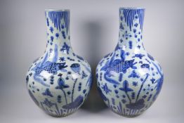 A pair of Chinese blue and white porcelain bottle vases decorated with carp in a lotus pond, 59cm