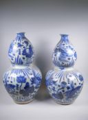 A near pair of Chinese blue and white porcelain double gourd vases decorated with carp in a lotus