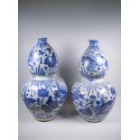 A near pair of Chinese blue and white porcelain double gourd vases decorated with carp in a lotus