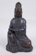 A Chinese bronze figure of Quan Yin seated and holding a ruyi, 23cm high