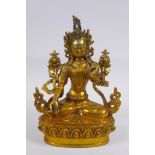 A Tibetan gilt bronze figure of a female deity seated on a lotus flower, impressed double vajra mark