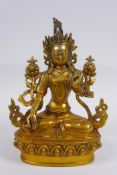 A Tibetan gilt bronze figure of a female deity seated on a lotus flower, impressed double vajra mark