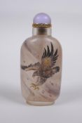 A Chinese reverse decorated glass snuff bottle depicting eagles in flight, 9cm high