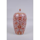 An early C20th Chinese iron red and white porcelain jar and cover with lotus flower decoration, 25cm