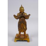 A Chinese gilt bronze figure of a stout warrior, impressed 4 character mark to the reverse, 23cm