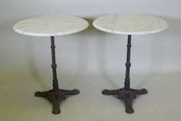 A pair of marble top bistro tables with cast iron bases, 73cm high x 61cm diameter
