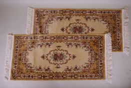 A pair of gold ground Kashmir runners with a floral medallion design, 142 x 68cm
