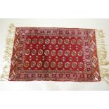 A vintage Persian rug with geometric designs on a red field, 94 x 150cm