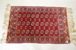 A vintage Persian rug with geometric designs on a red field, 94 x 150cm