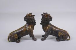 A pair of Chinese filled bronze kylin with gilt highlights, impressed seal mark to base, 14cm