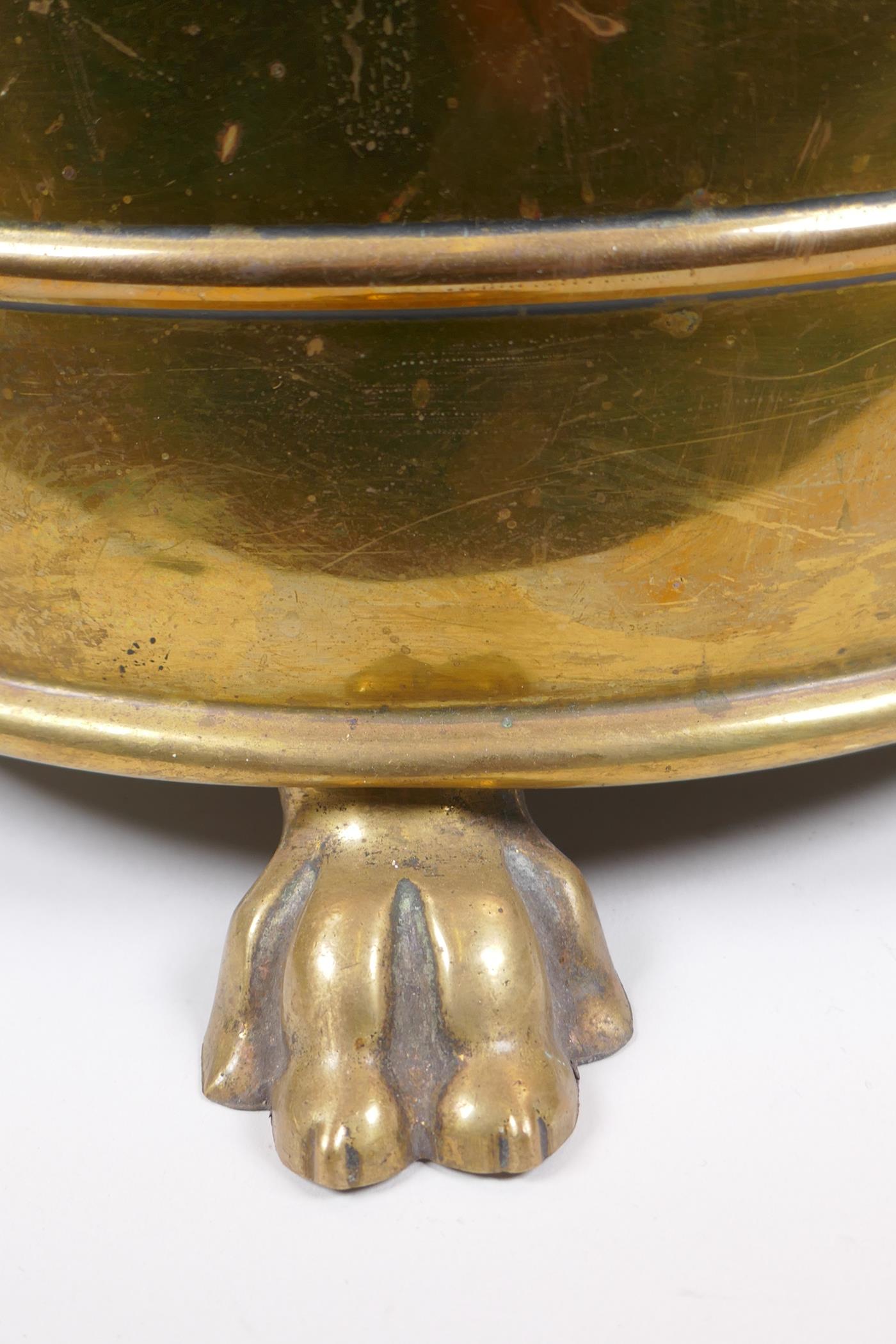 An antique brass coal scuttle with two lion mask loop handles, rams mask decoration and pawed - Image 4 of 4